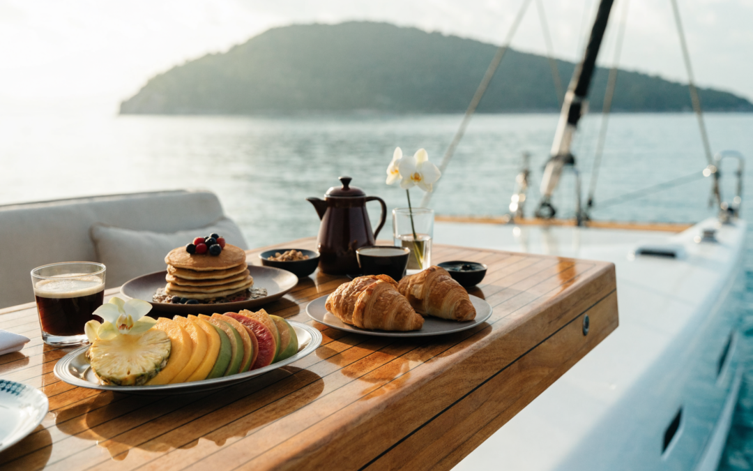 A yacht chef serving breakfast on deck aboard a crewed Caribbean catamaran